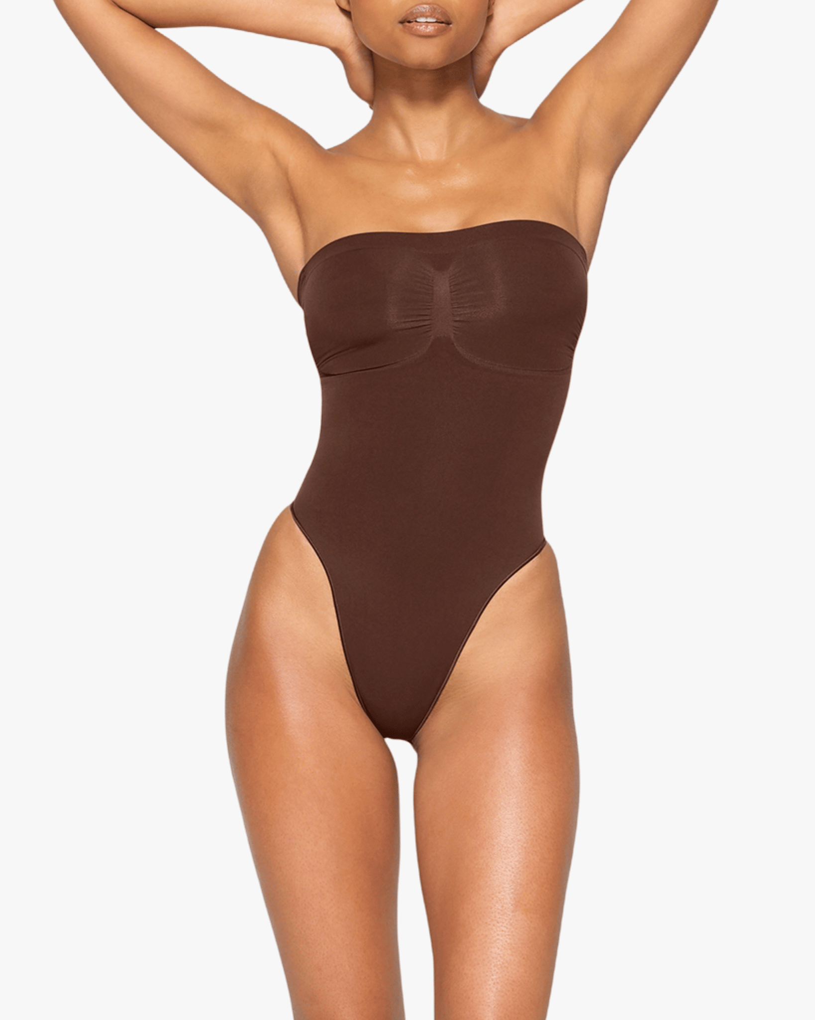 Brown strapless bodysuit worn by a model on a white background
