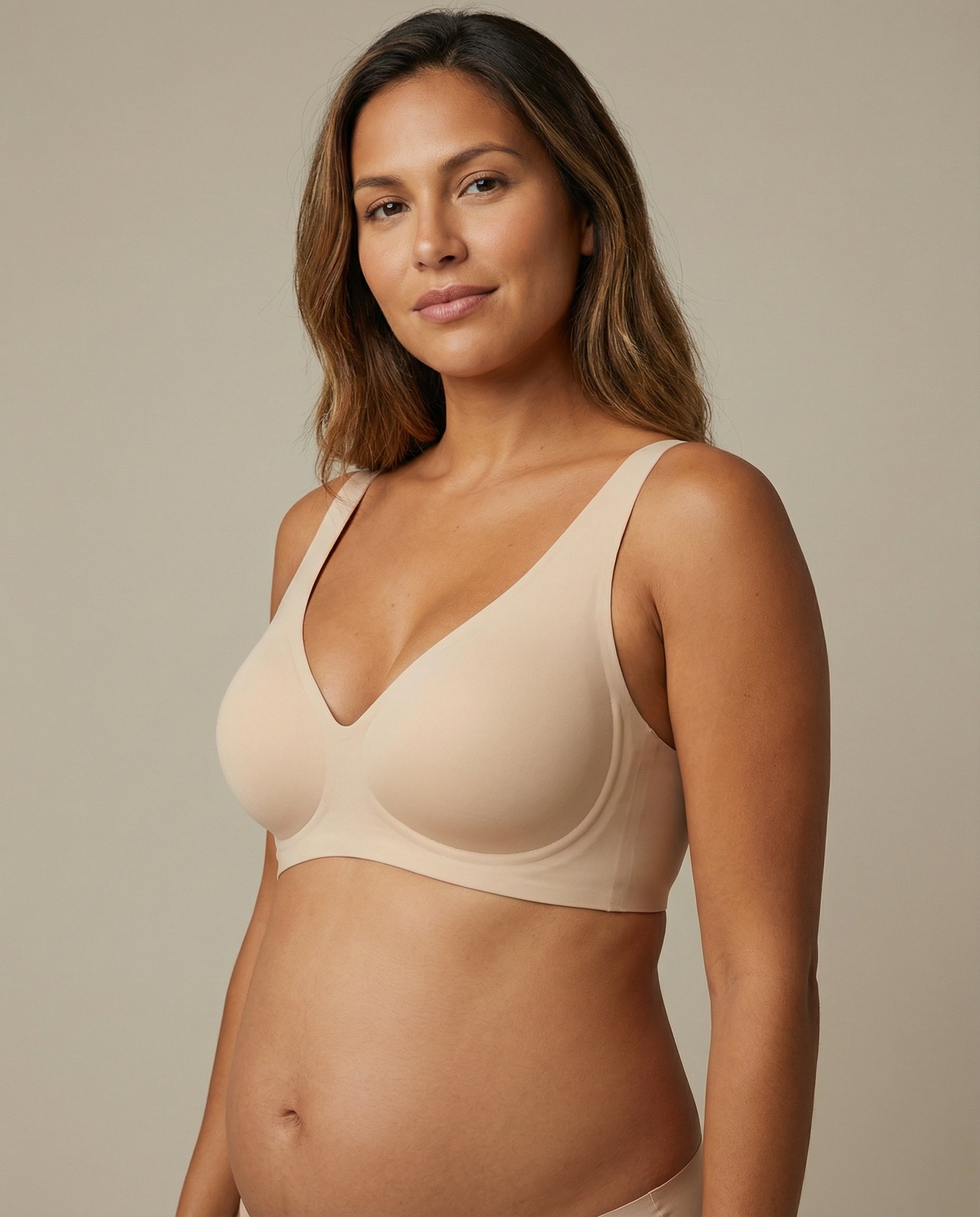 Woman wearing a beige bra against a neutral background