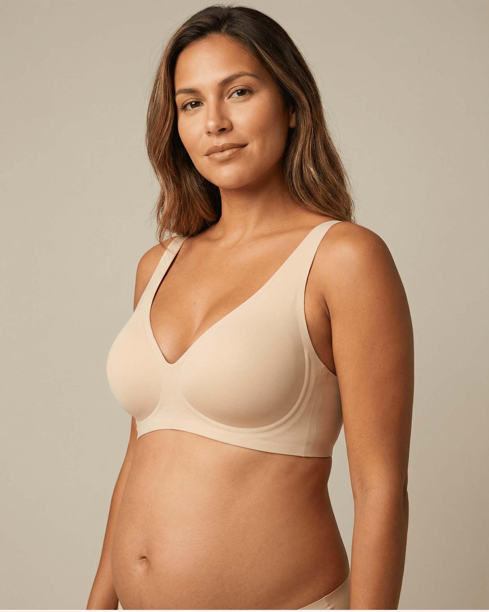 Woman wearing a beige bra against a neutral background
