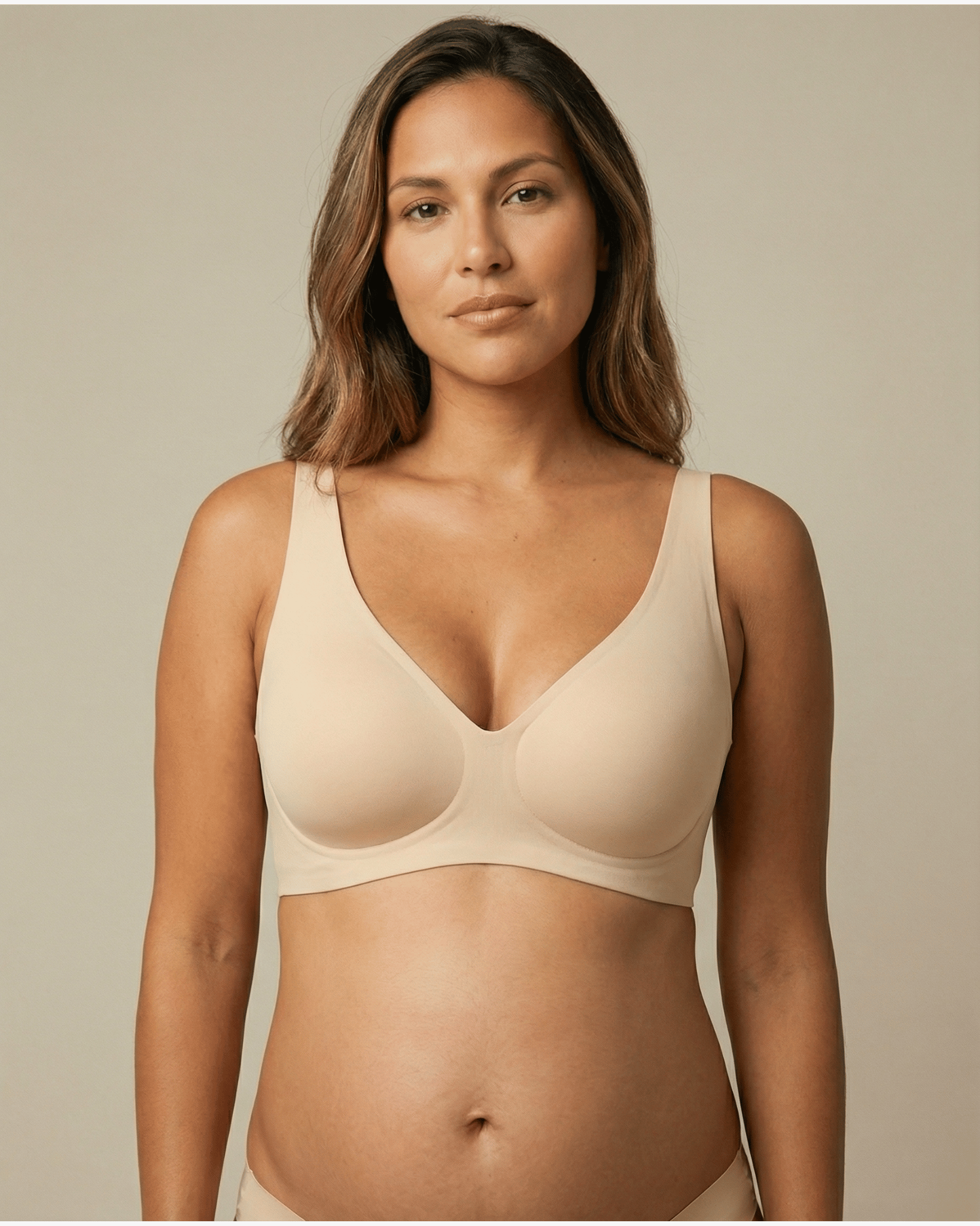 Woman wearing a beige bra against a neutral background
