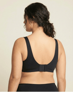 Black sports bra worn by a person on a beige background