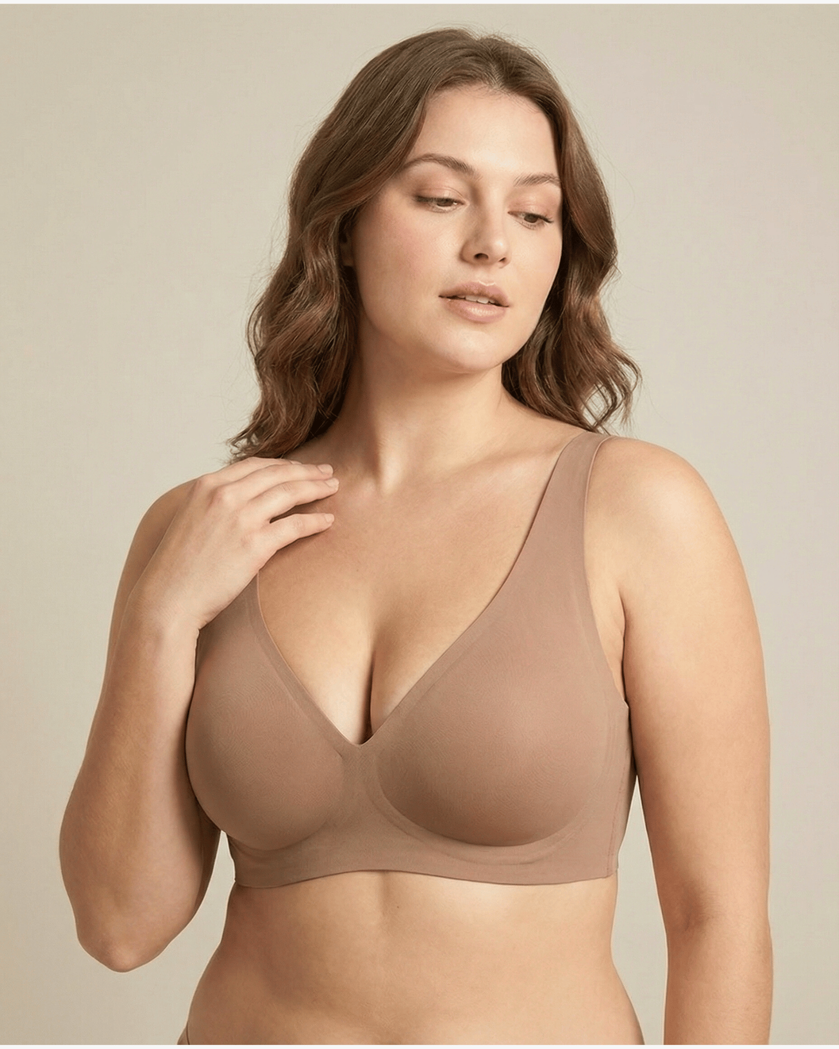 Woman wearing a beige bra against a plain background