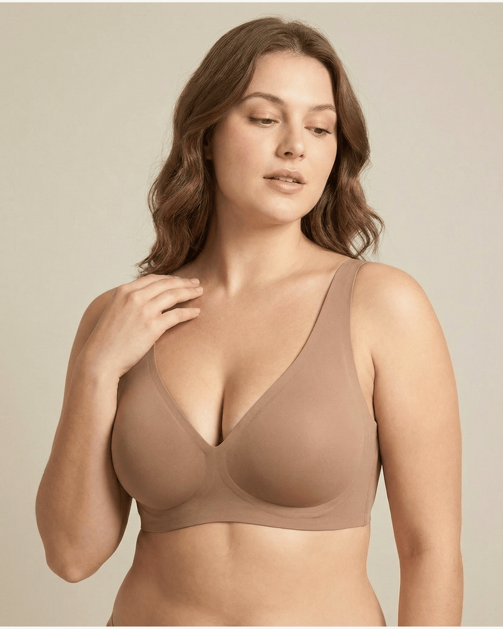 Woman wearing a beige bra against a plain background