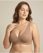 Woman wearing a beige bra against a plain background