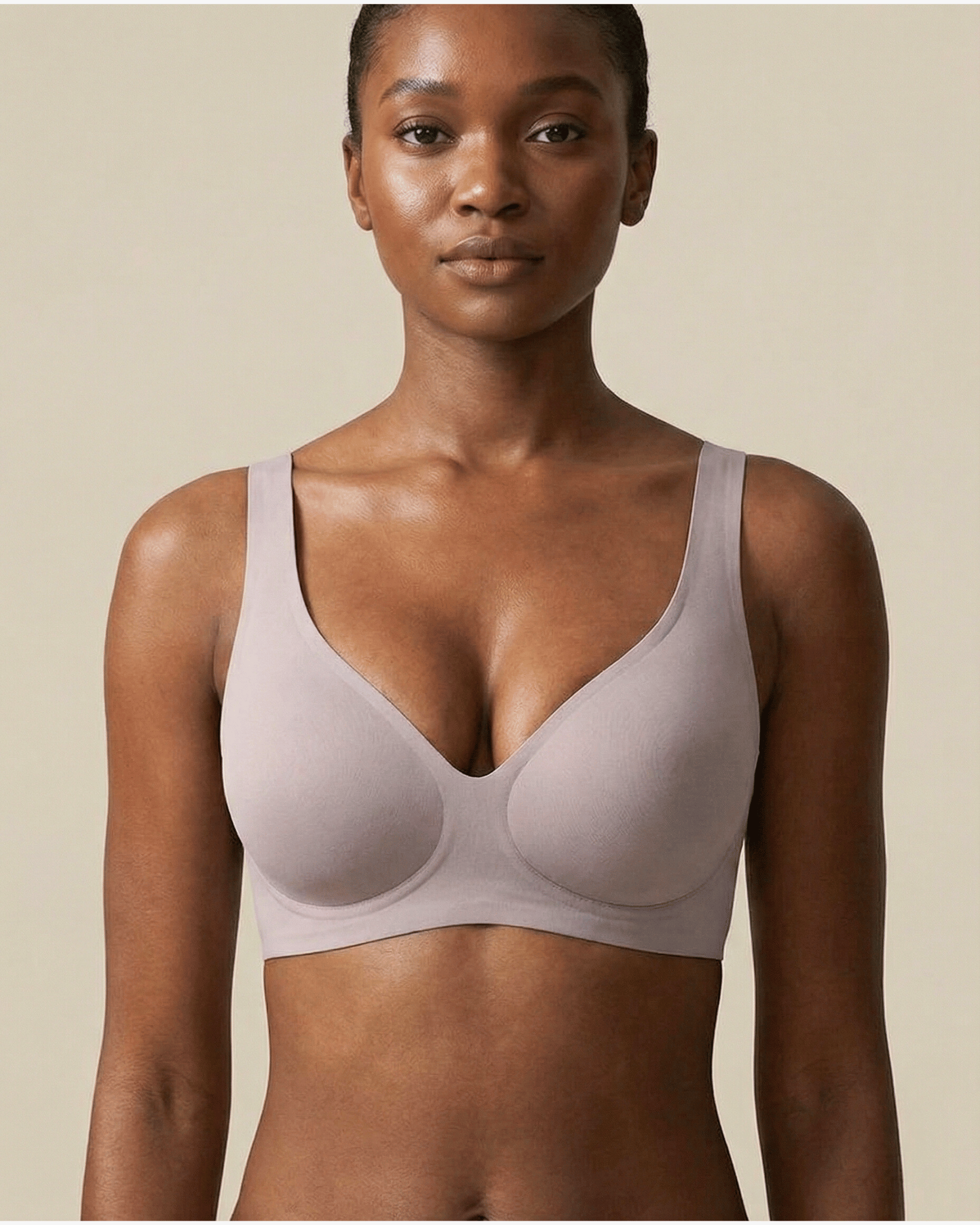 Woman wearing a light purple bra against a beige background