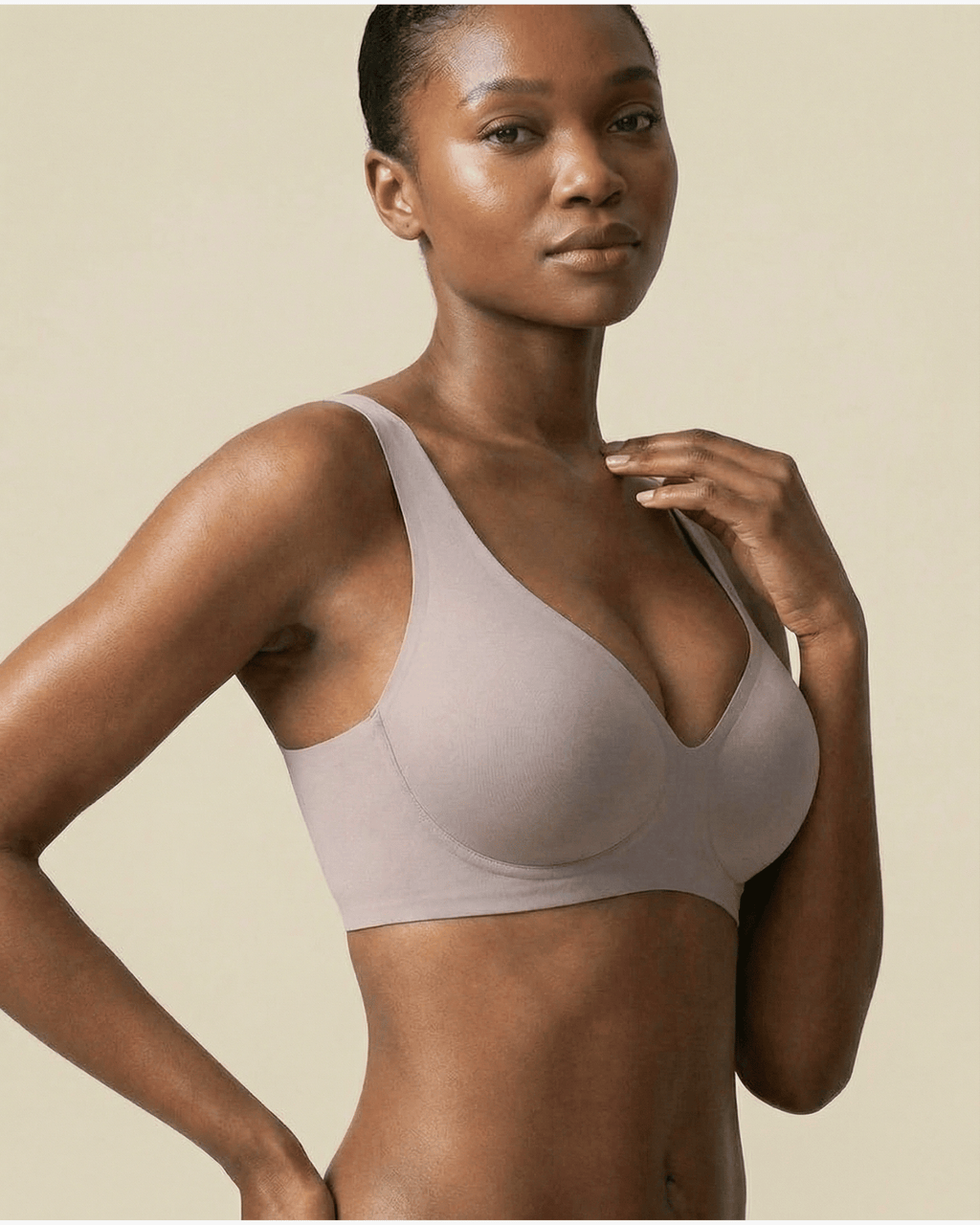 Woman wearing a beige bra against a beige background