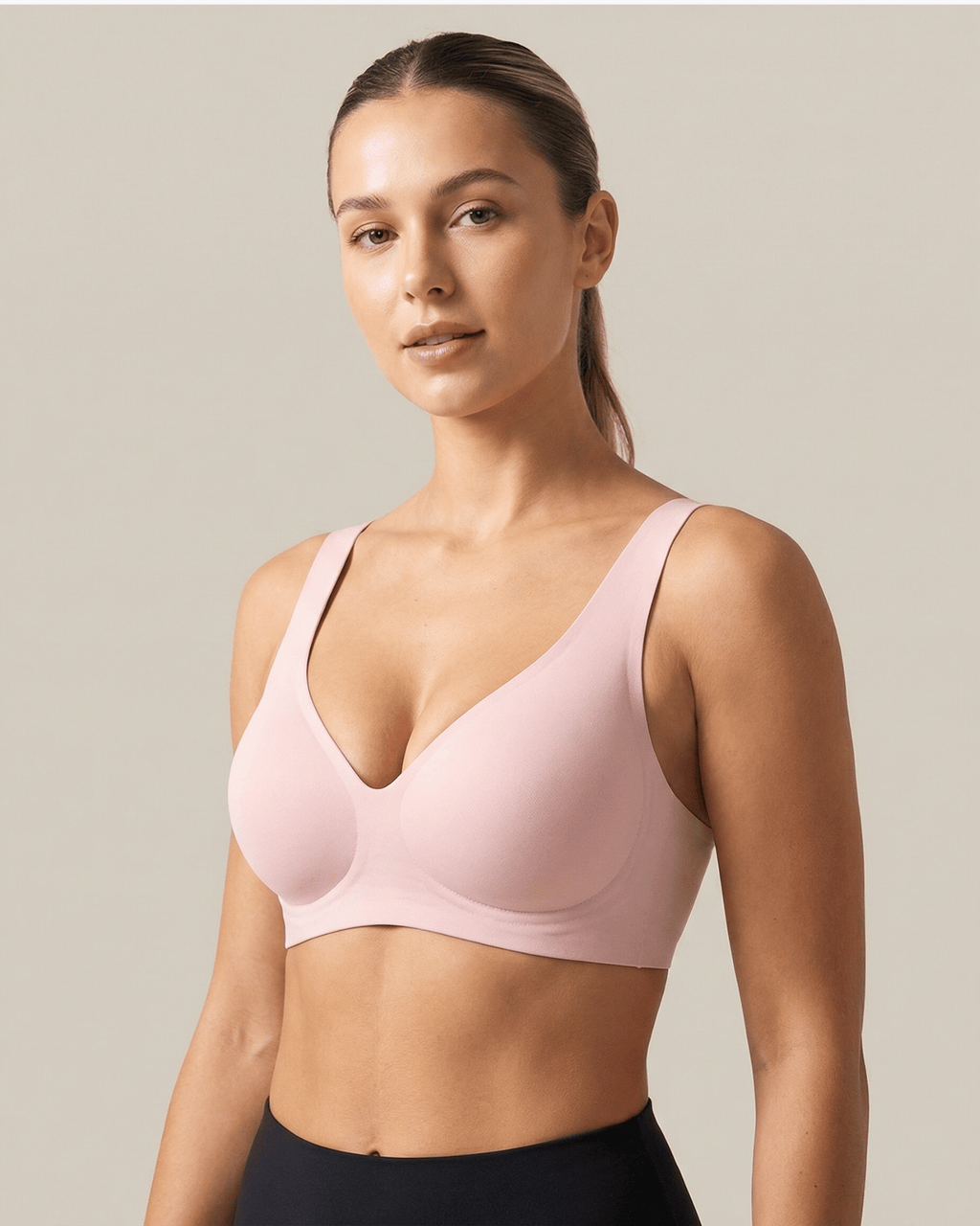 Woman wearing a pink sports bra against a neutral background