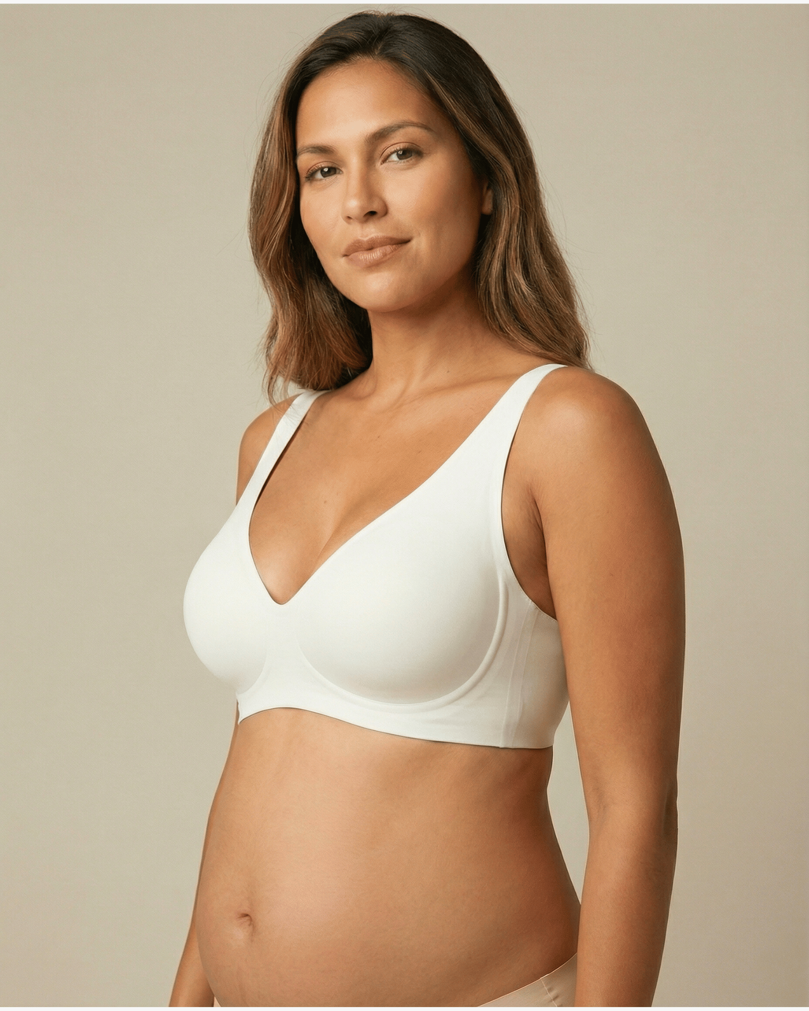 Woman wearing a white bra against a beige background