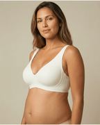 Woman wearing a white bra against a beige background