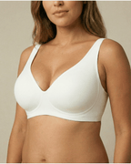 Woman wearing a white bra against a neutral background