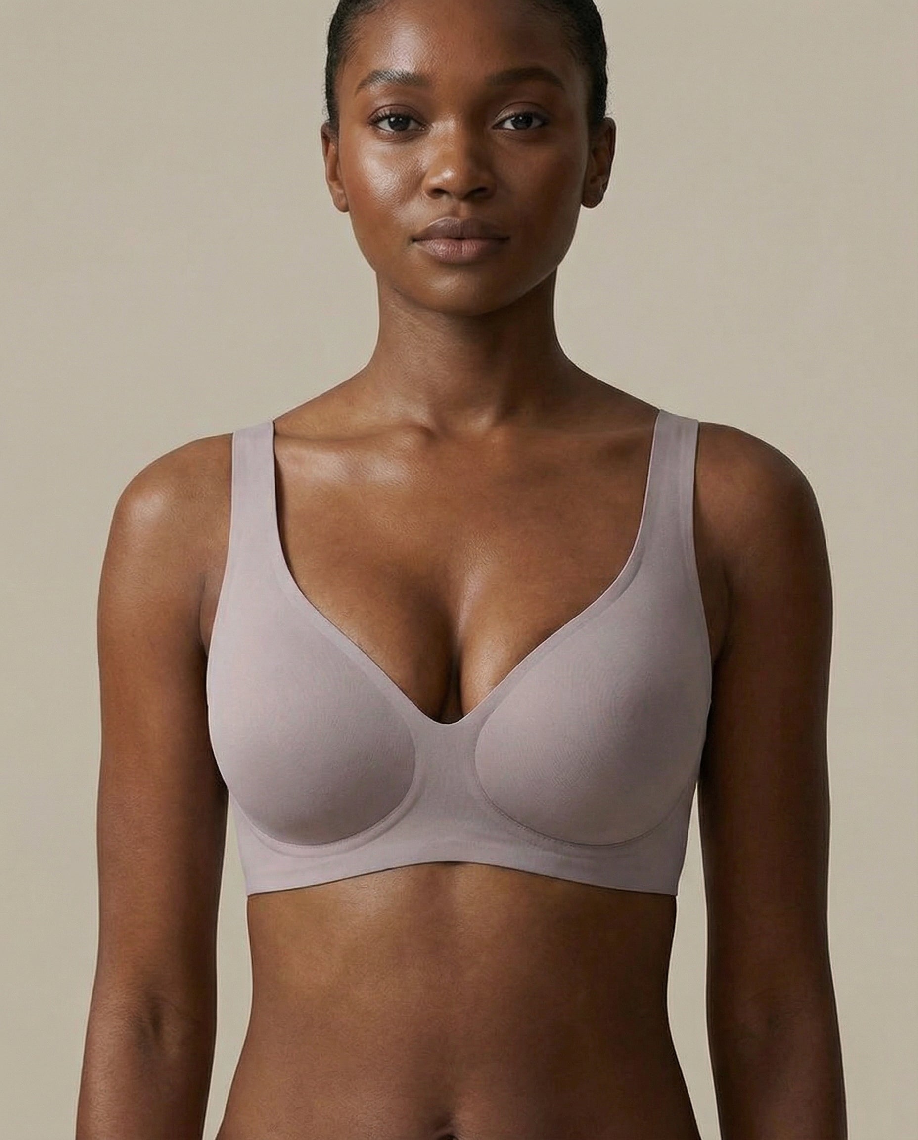 Woman wearing a light purple bra against a beige background