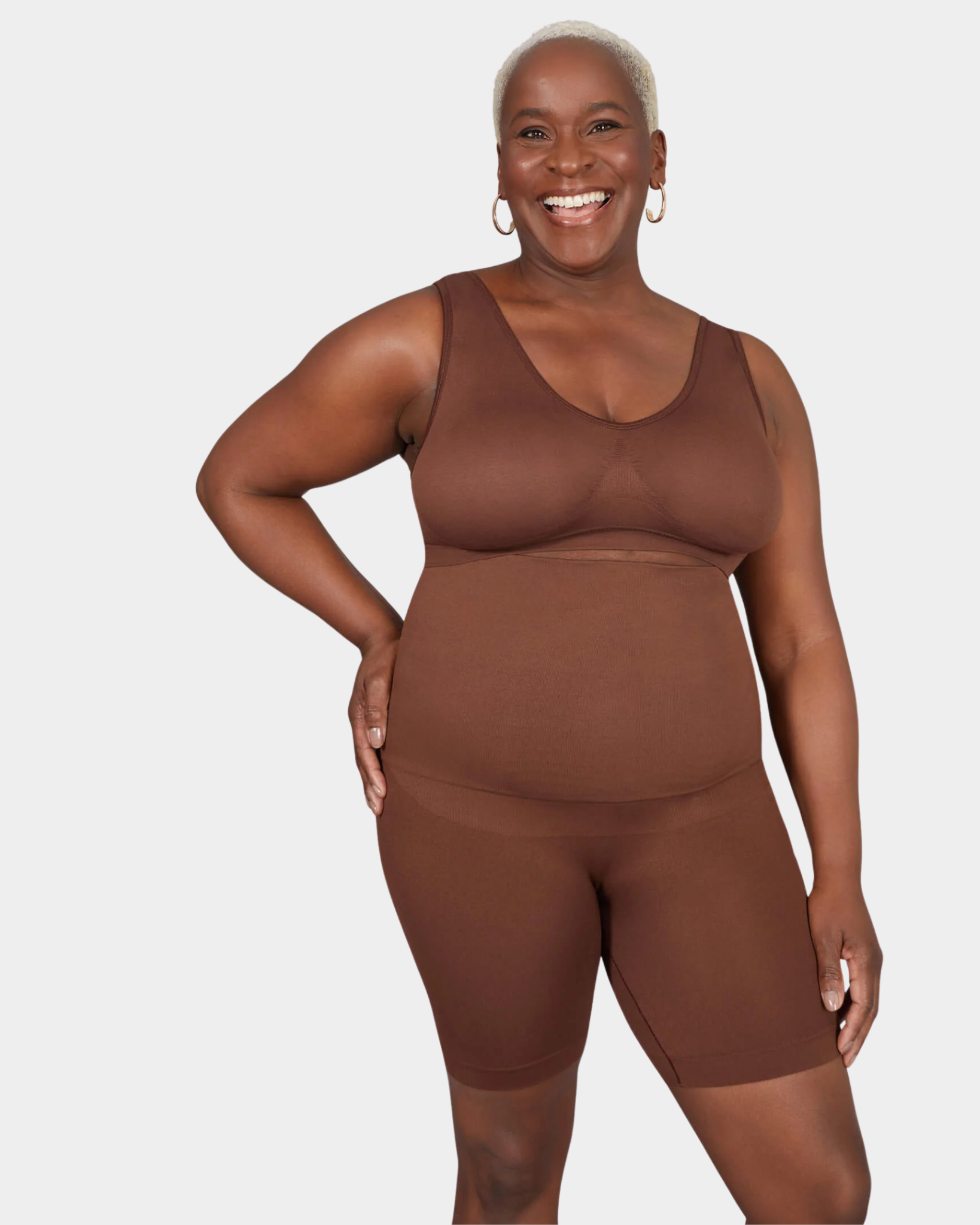 Woman wearing a brown tank top and shorts set on a white background