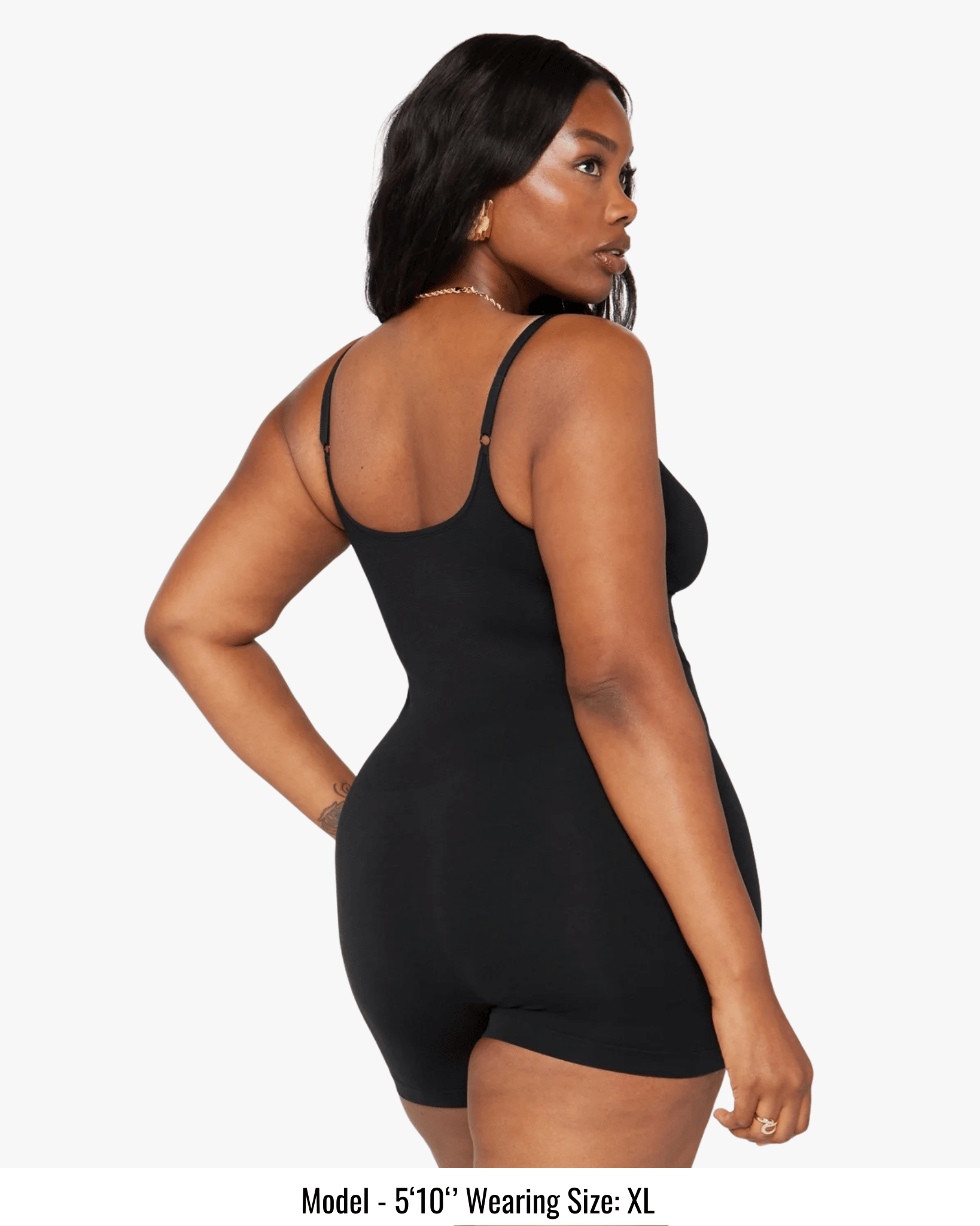 Woman wearing a black bodysuit on a white background