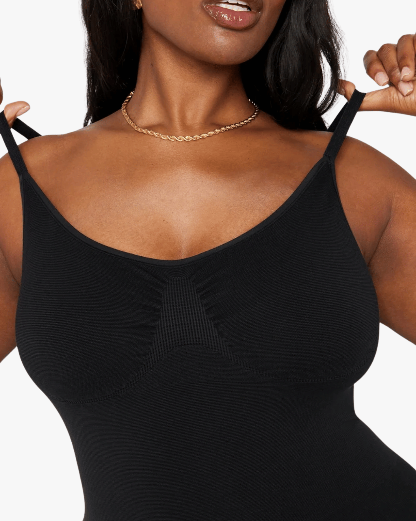 Woman wearing a black tank top against a white background