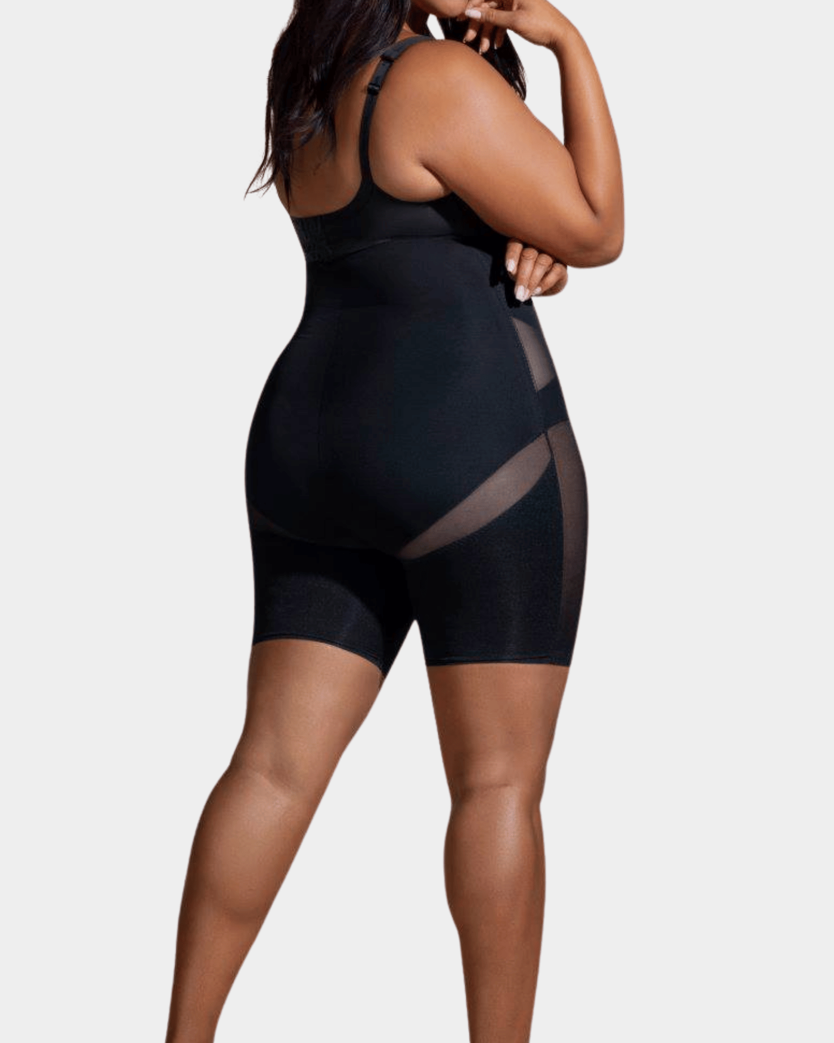 Black shapewear garment worn by a model on a white background